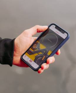 hand holding a cell phone connecting to the shell ride app