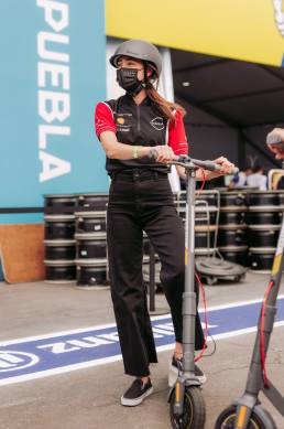 woman with helmet standing on a Shell RIDE electric scooter