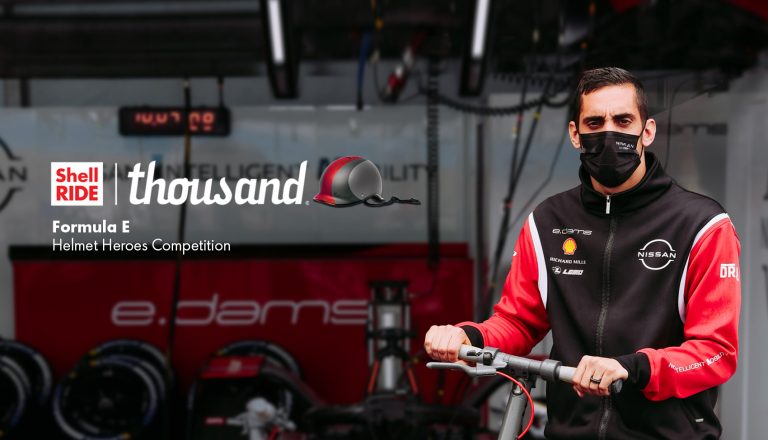 racecar driver riding a Shell Ride electric scooter
