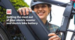 woman changing the battery in her shell ride electric bike